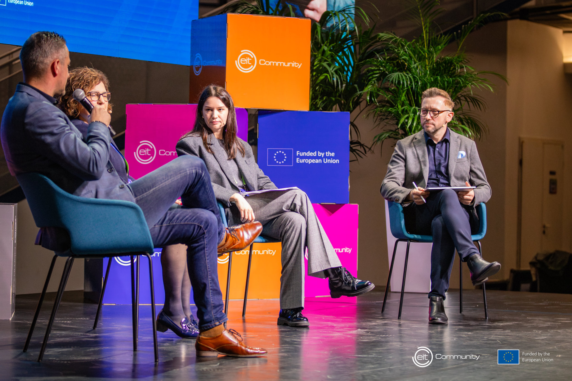 Andrew Wrobel speaking on a panel at the EIT Summit in Budapest, in front of EIT Community and European Union branding