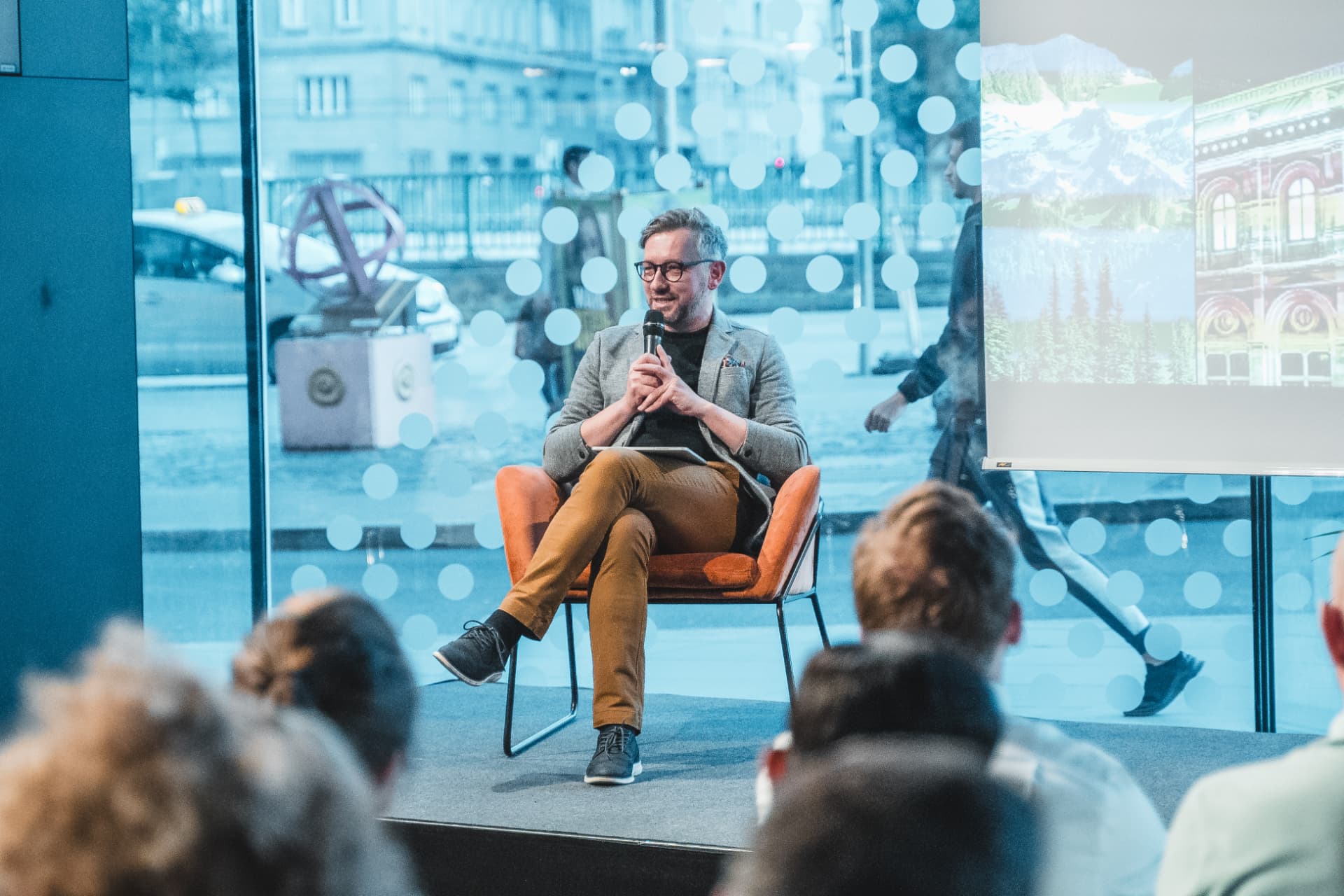 Andrew Wrobel in conversation in an armchair on stage at Visionary Minds in Vienna, with the audience in the foreground