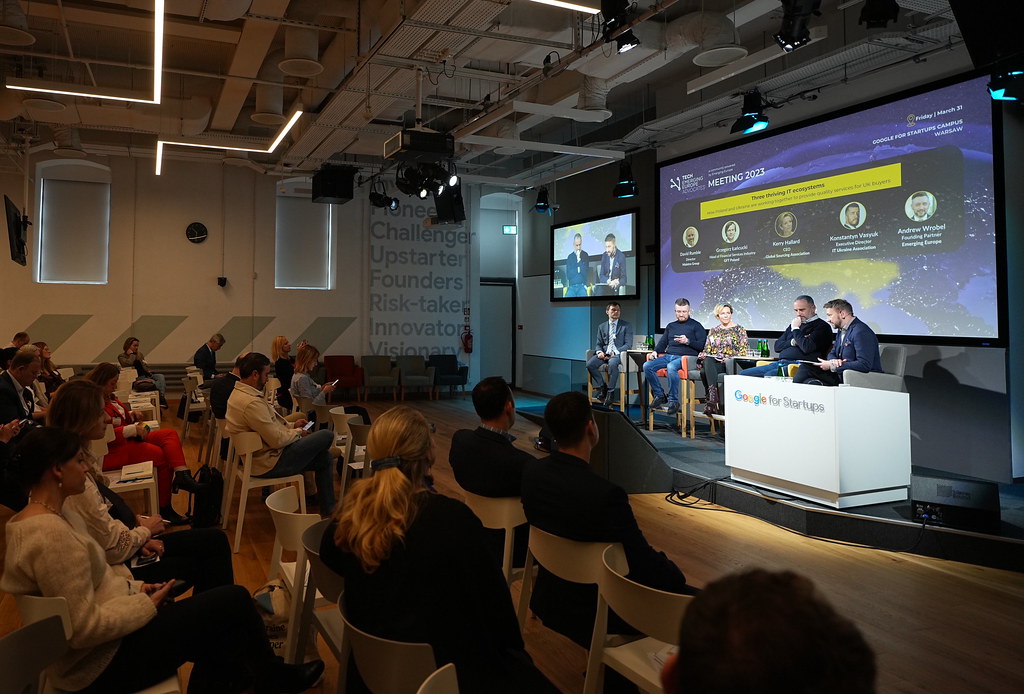 Andrew Wrobel seated at the right of a five-person panel at the Tech Emerging Europe Advocates Meeting 2023 in the Google for Startups Campus in Warsaw, a screen behind the stage reading 'Three thriving IT ecosystems' with the panelists' names